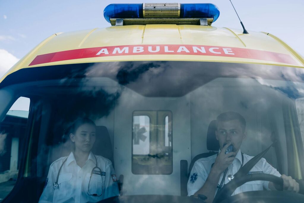 Paramedics in uniform driving an ambulance, showcasing teamwork and readiness in emergency situations.